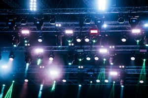 Luces de colores colgadas sobre la estructura del techo de un escenario
